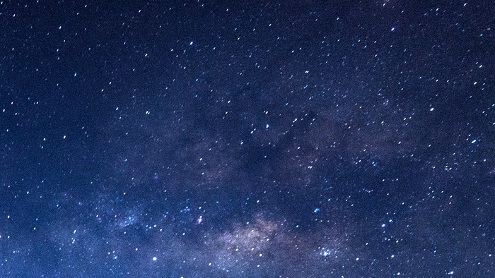 Weiter Sternenhimmel in dunklen Blautönen mit unzähligen leuchtenden Punkten. Die Milchstraße zieht sich als heller, leicht wolkiger Streifen quer durch das Bild und vermittelt Weite, Ruhe und Tiefe.