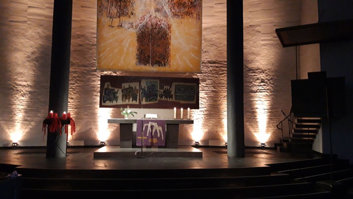 Elegante Bühnenausstattung in einer modernen Kapelle mit warmer Beleuchtung, Altar und künstlerischer Kulisse.