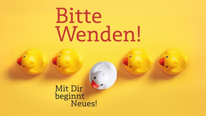 Eine verspielte Anordnung von Gummienten mit einer deutschen Botschaft über gemeinsame Neuanfänge.