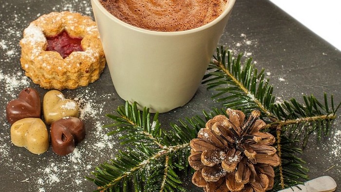 Weihnachtliche Szene mit Kaffee, Keksen und Tannenzapfen