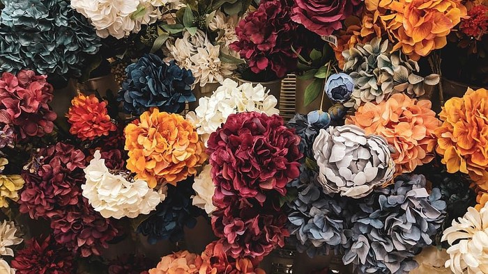 En rig blomstertapet med mange farver og typer af blomster.
