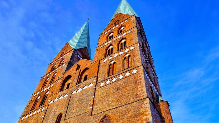 Gothischer Backsteinkirchturm unter blauem Himmel