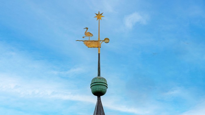 Wetterhahn mit Hahn und Stern vor blauem Himmel