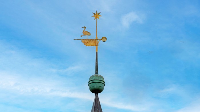 Wetterhahn mit Hahn und Stern vor blauem Himmel