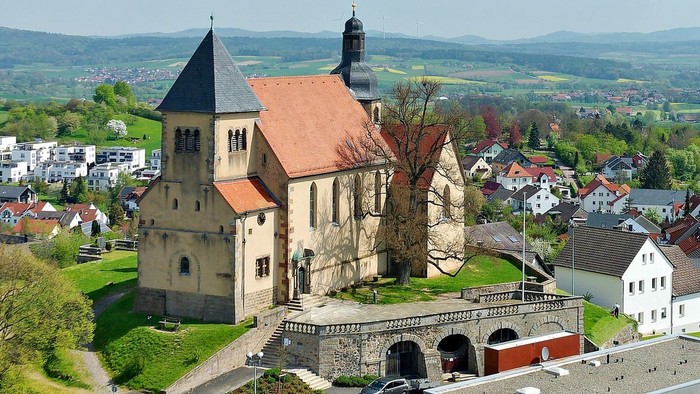 Historische Kirche in malerischem Dorf mit umliegender Landschaft