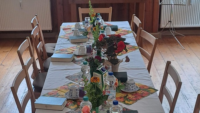 Ein festlich gedeckter Tisch in einem Raum mit einem Altar.