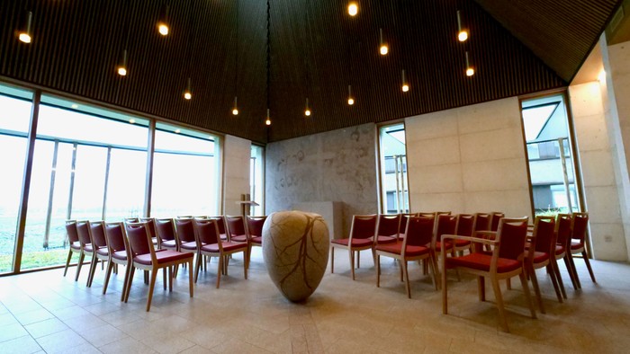 En moderne konferenceværelse med røde stoler og store vinduer.