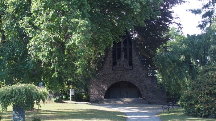 Ein alter Backofen aus Ziegelsteinen umgeben von Bäumen und Büschen