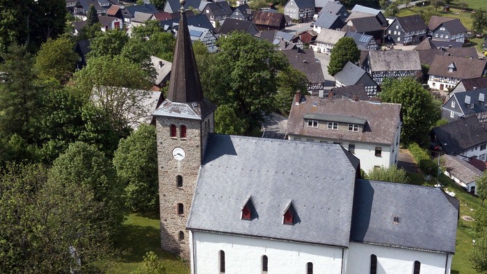 Kirchliches Gebäude in ländlicher Umgebung mit vielen Häusern und Bäumen