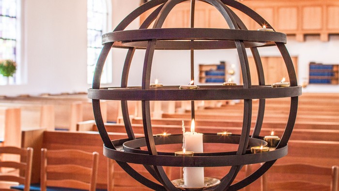En stor globuslygte med flere lysede lygter i en kirke.