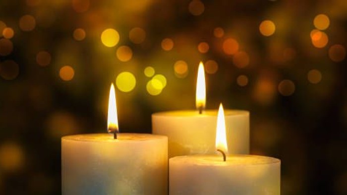 Tre lysende lysekander foran en lysete baggrund