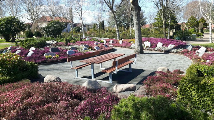 En roselund med bænke og blomster.