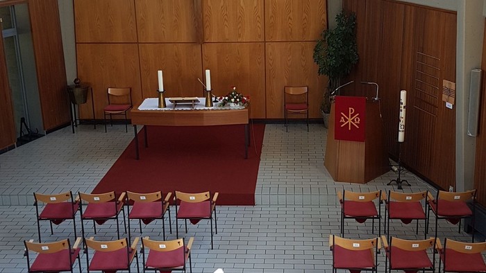 Leere Kirche mit roten Stühlen und Holzvertäfelung