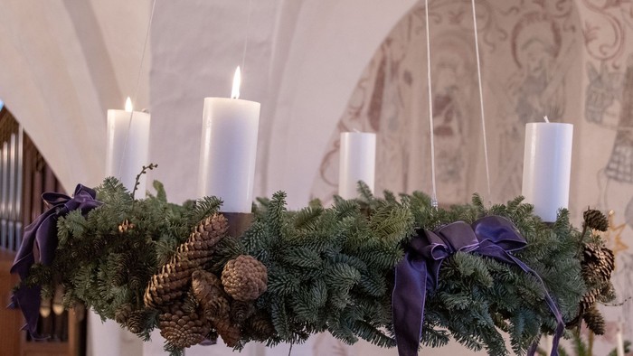 En hængende julekrans med lysende lygter og nødder i en indendørs lokalitet