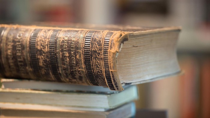 Ein alter Buchstapel mit einem dicken Wälzer obenauf