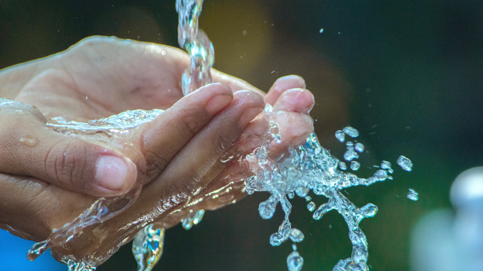 Hände halten Wasser, das herausspritzt