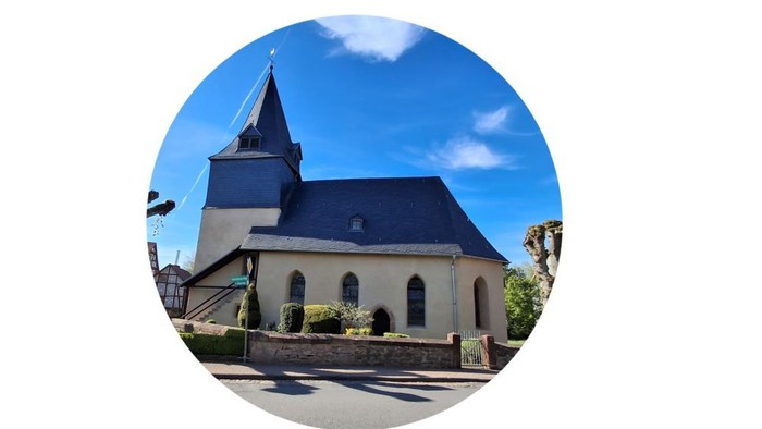 Kirche mit blauem Dach und Turmspitze unter blauem Himmel