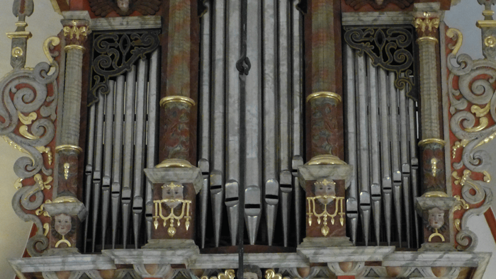 Nahaufnahme der Ender Orgel mit Orgelpfeifen. Die Orgelpfeifen sind silber. Die Orgel ist reich verziert.