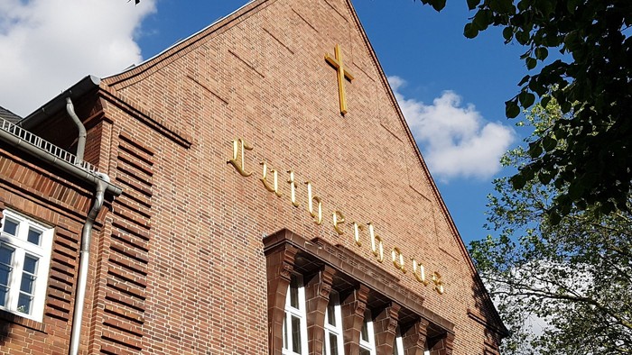 Ziegelkirche mit Kreuz und Fenster.