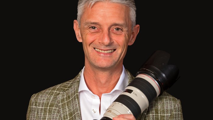 Mand med hvid hår og kamera.