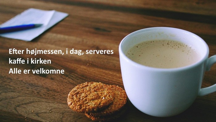 Et cup med kaffe og en kage på bordet