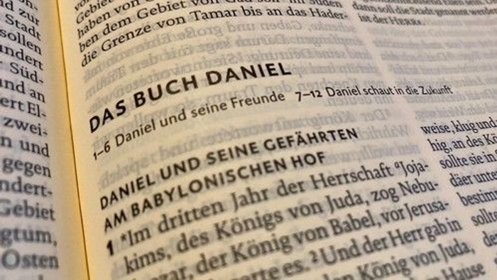 Nahaufnahme einer deutschen Bibel, die das Buch Daniel mit Kapitel- und Versangaben zeigt.