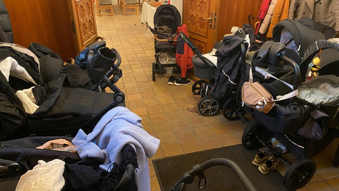 Våbenhus fyldt af barnevogne ved babygudstjeneste