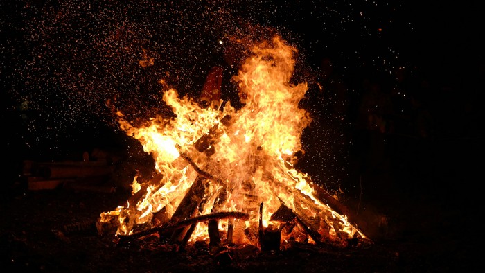 En stor og opfyldt bonfire brænder i mørket.
