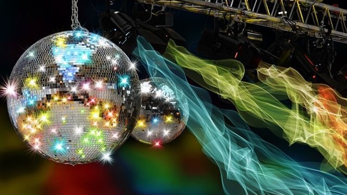 Lebendige Discokugeln und farbenfrohe Lichtspuren schaffen eine dynamische, energiegeladene Bühnenbeleuchtung.