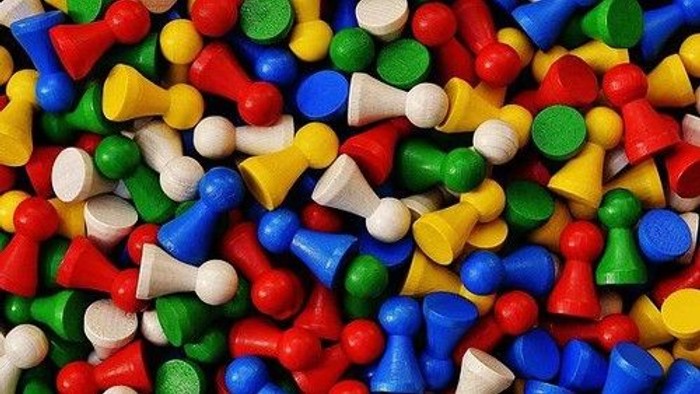 Bunte Auswahl an Plastik-Reißzwecken und Flaschendeckeln in leuchtendem Rot, Blau, Grün, Gelb und Weiß.