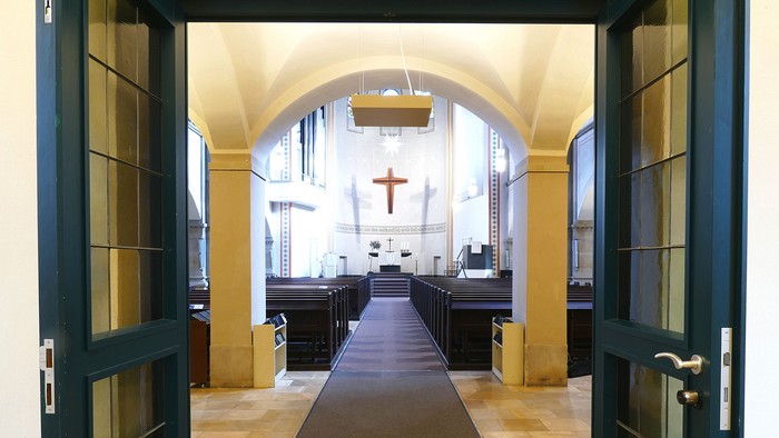 Durchgang in eine Kirche mit Kreuz und Bänken