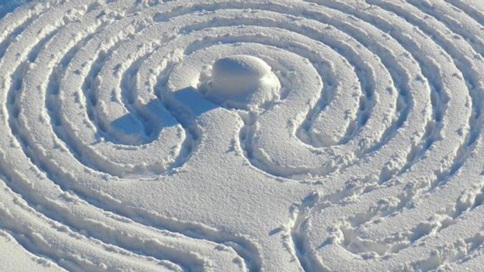 Ein Schneemuster in Form eines Labyrinths im Schnee.