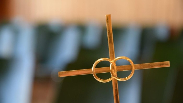 Ein hölzernes Kreuz mit zwei goldenen Ringen in der Mitte