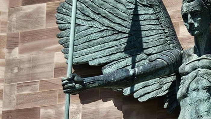 Die Statue eines Kriegers mit einem Speer vor einer Ziegelmauer