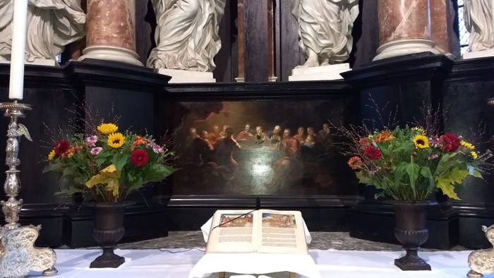 Altar mit Blumenarrangements und aufgeschlagenem Buch