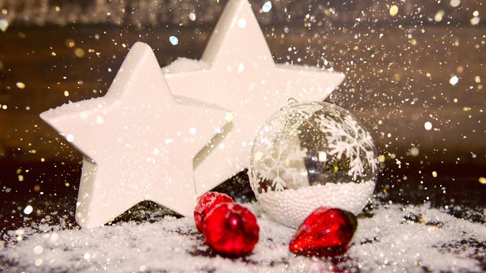 Weiße Sterne und glitzernde Kugeln im Schnee