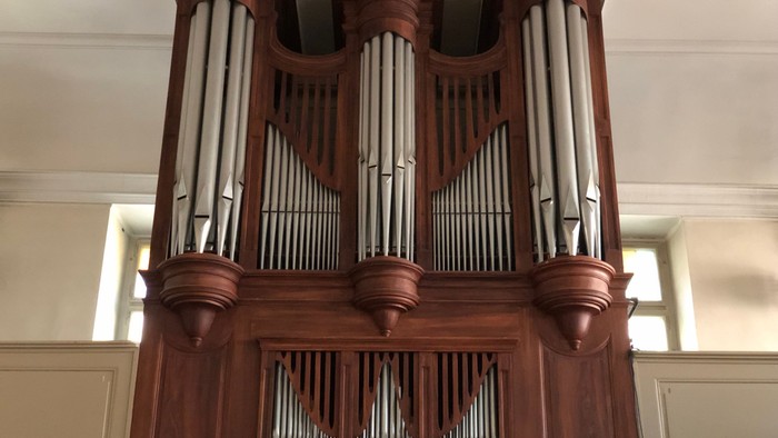 Ein großes, hölzernes Kirchenorgel mit zahlreichen Pfeifen.
