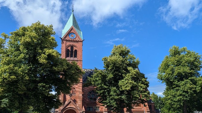 Blick auf Lutherkirche mit Turm vor grünen Bäumen