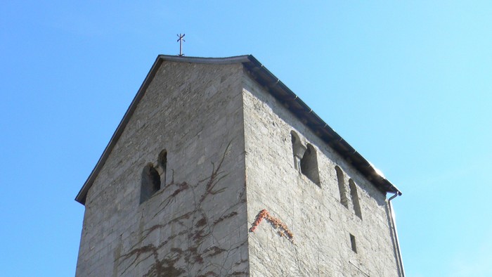 Hoher Steinturm mit Efeu, der daran wächst.