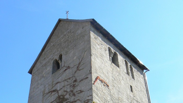 Hoher Steinturm mit Efeu, der daran wächst.