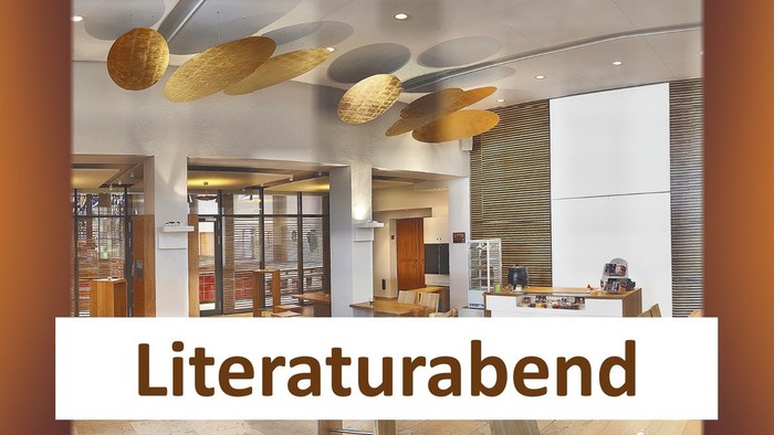 Modernes Foyer mit stilvollen Hängeleuchten und dem Schriftzug „Literaturabend“, der auf eine literarische Abendveranstaltung hinweist.