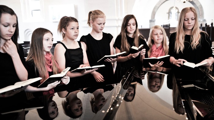 En gruppe piger synger i en kirke.