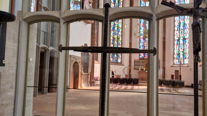 Modernes Podest mit Kreuzständern in einer großen, gewölbten Kathedrale mit farbenfrohen Buntglasfenstern.