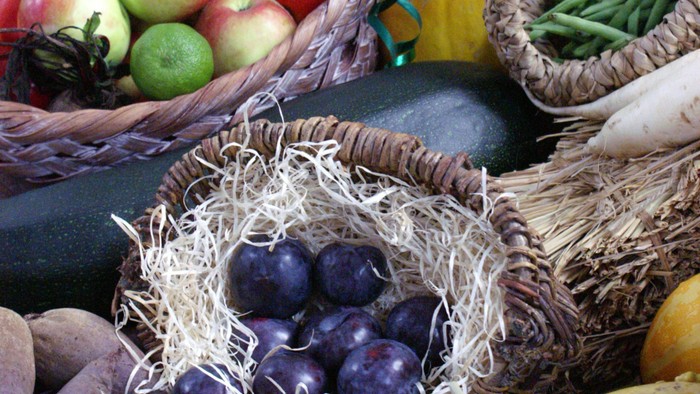 Reichhaltige Körbe mit Obst, Gemüse und weiterem Erntegut