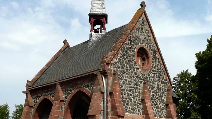 Kleine Kirche mit spitzem Turm und Ziegelmauerwerk