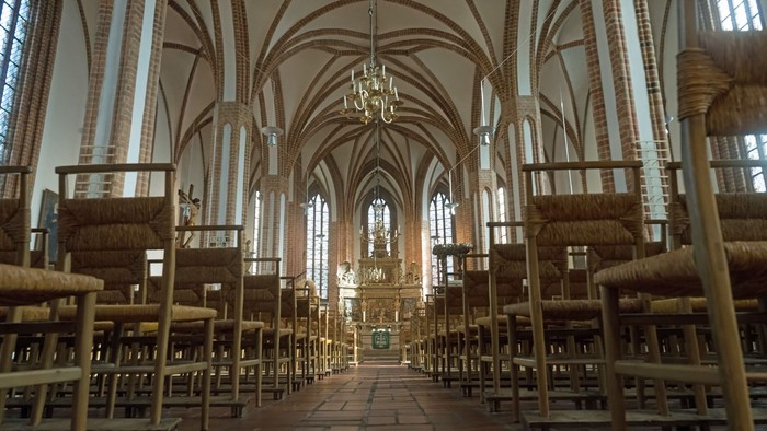 Großzügige Kirche mit hohen Bögen und zahlreichen Bänken.