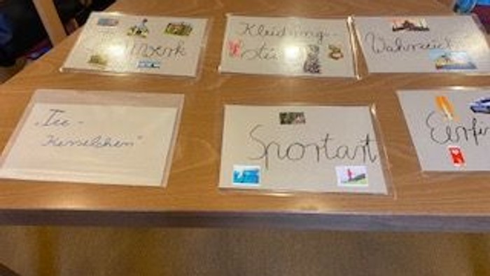 Handschriftliche Notizen und Karten mit verschiedenen Botschaften und Aufklebern auf einem Holzregal.