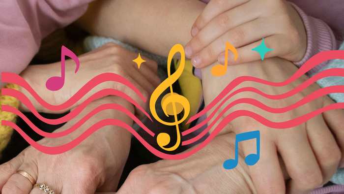 En babys fødder leger med en tangent på et legetøjs klaver omgivet af farverige noder og musikalske symboler.