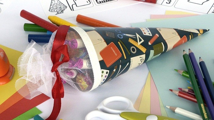 Buntstifte, Scheren und Bastelpapier auf einem Tisch