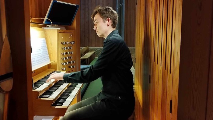 Mand spiller orgel i kirke.